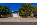 Single-story house with solar panels and a two-car garage at 14428 W Carlin Dr, Surprise, AZ 85374