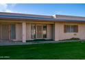 Light beige building exterior with two entrances, and a grassy area at 12810 N 113Th Ave # 7, Youngtown, AZ 85363