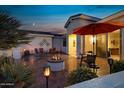 Inviting backyard patio with fire pit, seating area, and umbrella at 42818 W Morning Dove Ln, Maricopa, AZ 85138