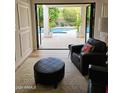 View of backyard pool through folding glass doors from living room with leather seating at 2468 S Salida Del Sol --, Chandler, AZ 85286