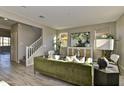 Living area featuring green sofa and a staircase at 37536 W Patterson St, Maricopa, AZ 85138