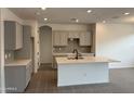 Modern kitchen with an island, gray cabinets, and tile flooring at 24066 N 162Nd Ln, Surprise, AZ 85387