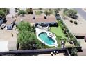 Aerial view of a house with a kidney-shaped pool and putting green at 2610 E Nisbet Rd, Phoenix, AZ 85032