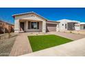 Modern curb appeal with artificial turf and brick driveway at 7380 W Bent Tree Dr, Peoria, AZ 85383