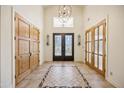 Elegant entryway with double doors, hardwood floors, and a beautiful chandelier at 5302 E Mercer Ln, Scottsdale, AZ 85254