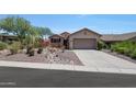 Front view of a tan house with a gravel driveway and landscaping at 41333 N Belfair Way, Anthem, AZ 85086