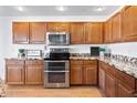 Modern kitchen with wood cabinets, granite countertops, and stainless steel appliances at 31777 N Sundown Dr, San Tan Valley, AZ 85143