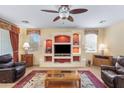 Living room with built-in shelving and a large TV at 42609 W Milky Way, Maricopa, AZ 85138