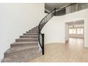 Grand curved staircase with wrought iron railings and carpeted steps at 14044 W Bronco Trl, Surprise, AZ 85387