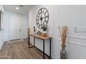 Bright entryway with wood-look floors, console table and large clock at 11224 E Upton Ave, Mesa, AZ 85212