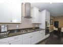 Modern kitchen with white cabinets, granite countertops, and stainless steel appliances at 10744 W Briles Rd, Peoria, AZ 85383