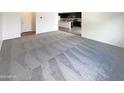 Spacious living room with carpeted floor and view into kitchen at 2178 N 212Th Ln, Buckeye, AZ 85396