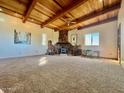 Living room with a stone fireplace and wood-beamed ceiling at 50644 N 33Rd Ave, New River, AZ 85087