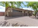 Front view of home with a two-car garage and brick facade at 10005 W Spur Dr, Peoria, AZ 85383