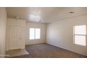 Bright living room with neutral carpeting and ample natural light at 9419 W Sheridan St, Phoenix, AZ 85037