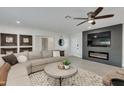 Bright and airy living room with a modern fireplace and large TV at 8247 E Devonshire Ave, Scottsdale, AZ 85251