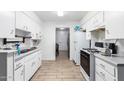 Galley-style kitchen with white cabinets and gas range at 4727 N 50Th Dr, Phoenix, AZ 85031