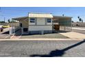 Tan mobile home with carport and small fenced yard at 7300 N 51St Ave # 160, Glendale, AZ 85301