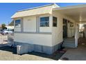 Side view of a tan mobile home with stairs and small yard at 7300 N 51St Ave # 160, Glendale, AZ 85301