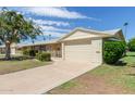 Ranch-style home with attached garage and well-manicured lawn at 10318 W Desert Forest Cir, Sun City, AZ 85351