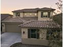 Tan two-story house with tile roof, shutters, and a three-car garage at 19591 W Lincoln St, Buckeye, AZ 85326