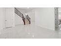 Bright interior with white tile flooring and a staircase with an ornate railing at 19591 W Lincoln St, Buckeye, AZ 85326