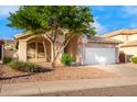 Single-story house with a two-car garage and desert landscaping at 902 E Goldenrod St, Phoenix, AZ 85048