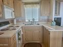 Galley kitchen with light wood cabinets and standard appliances at 7750 E Broadway Rd # 10, Mesa, AZ 85208