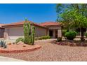 Tan house with tile roof, cacti, and desert landscaping at 16428 W Labyrinth Ln, Surprise, AZ 85374