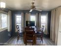 Bright dining area with wood table and chairs, ceiling fan, and large windows at 2323 W Pomo Ave, Apache Junction, AZ 85119