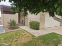 Front entrance of a condo with gate, landscaping, and a pergola at 3345 E University Dr # 25, Mesa, AZ 85213