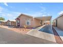 Tan and maroon manufactured home with carport and desert landscaping at 6835 W Taylor St # 208, Phoenix, AZ 85043
