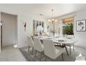 Virtually staged dining room with a large table and chandelier at 16121 W Silver Falls Dr, Surprise, AZ 85374