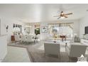 Bright living room features a dining area and virtually staged furniture at 16121 W Silver Falls Dr, Surprise, AZ 85374