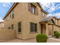 Two story tan house with landscaping and a walkway at 915 E Agua Fria Ln, Avondale, AZ 85323