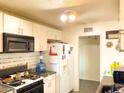 Bright kitchen features white cabinets, gas stove, and refrigerator at 6767 N 7Th St # 217, Phoenix, AZ 85014