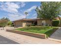 Tan house with a landscaped yard and a two-car garage at 5119 W Onyx Ave, Glendale, AZ 85302