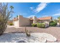 Tan stucco house with a tile roof, a two-car garage, and desert landscaping at 9614 E Bud Ct, Sun Lakes, AZ 85248