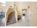 Curved staircase with carpeted steps in a home entryway at 10418 W Roanoke Ave, Avondale, AZ 85392