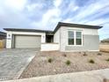 Front exterior view of a single-story home with a paved driveway and desert landscaping at 22730 E Roundup Way, Queen Creek, AZ 85142