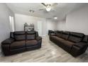 Living room with two brown leather reclining sofas and wood-look floors at 2941 N 19Th Ave # 84, Phoenix, AZ 85015