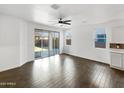 Spacious living area featuring wood-look tile flooring and a ceiling fan at 18212 W Illini St, Goodyear, AZ 85338