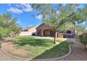 Spacious backyard with grassy lawn, covered patio, and spa at 1594 E Desert Breeze Dr, Casa Grande, AZ 85122