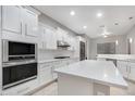Modern kitchen with white cabinets, quartz counters, and stainless steel appliances at 32029 N 20Th Ln, Phoenix, AZ 85085