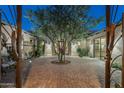 Charming courtyard with a central tree and wrought-iron gates at 36495 N Livorno Way, Scottsdale, AZ 85262