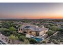 Luxury home with pool and desert landscape views at sunset at 36495 N Livorno Way, Scottsdale, AZ 85262