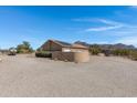 House exterior showcasing a three-car garage, solar panels, and desert landscaping at 77 S Arroya Rd, Apache Junction, AZ 85119