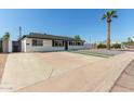 Updated mid-century home with white exterior, black accents, and a spacious front yard at 538 N 74Th St, Scottsdale, AZ 85257