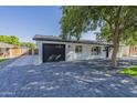 Ranch home with gray brick driveway and black garage door at 3628 E Weldon Ave, Phoenix, AZ 85018