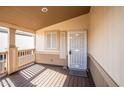 Covered front porch with wood-look flooring and a metal door at 9302 E Broadway Rd # 1, Mesa, AZ 85208